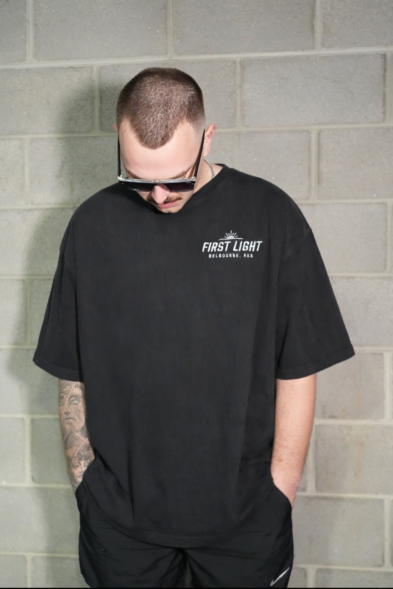 Man wearing the FIRST LIGHT Dawn heavyweight tee in washed black, oversized fit with dropped shoulder